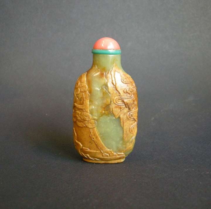 Snuff bottle jade russet and green sculpted with figure rocks and clouds